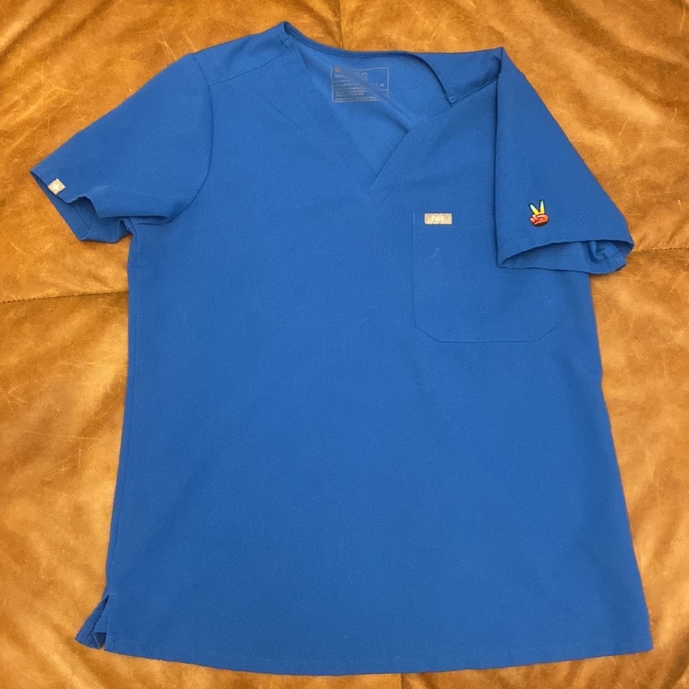 Royal blue fig Catarina scrub top with equality peace sign on left shoulder